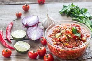 kom van salsa met ingrediënten foto