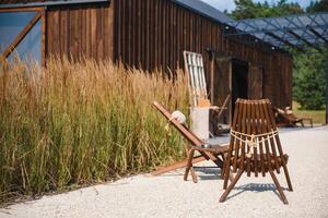 buitenshuis al fresco stoelen en tafel Aan een houten dek Bij zonsondergang in de voorjaar met druif wijnstokken en heuvels in de achtergrond, napa vallei, Californië Verenigde Staten van Amerika foto