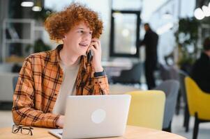 attent vent freelancer in gewoontjes kleren browsen laptop terwijl werken Aan project Aan terras van cafe in dag. foto