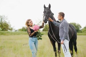 paar in liefde hebben pret in natuur. jong paar met een paard. foto