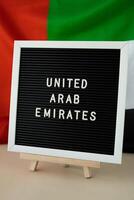 tekst Verenigde Arabisch emiraten Aan achtergrond golvend vlag van vae. nationaal vakantie, onafhankelijkheid herdenking dag moslim, Gefeliciteerd. Arabisch vakantie. advertentie van Dubai viering foto