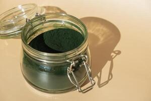 biologisch blauw groen algen spirulina poeder voedsel in glas kan. Gezondheid voordelen van spirulina chlorella. vitamines en mineralen naar eetpatroon. ontgiften dieet supplement zeewier superfood concept foto