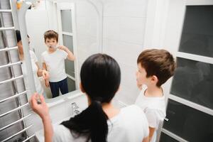 glimlachen moeder en kind zoon poetsen tanden in badkamer foto