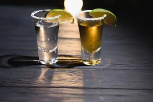 Mexicaans tequila met limoen en zout Aan rustiek hout achtergrond. ruimte voor tekst. concept luxe drankje. alcoholisch drinken concept. foto