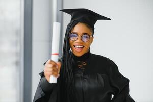 gelukkig Afrikaanse Amerikaans vrouw leerling met diploma Bij diploma uitreiking foto