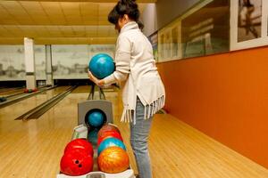 senior vrouw kiezen een bal in een bowling club. foto