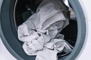 vuil kleren in het wassen machine. het wassen machine bezig met laden foto