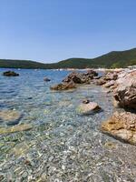 zeegezicht met Doorzichtig turkoois water tussen rotsen en stenen. vakantie, zomer vakantie foto