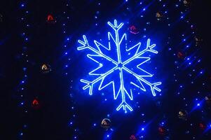 mooi groot blauw decoratief glimmend gloeiend sneeuwvlok Aan een donker achtergrond. avond feestelijk Kerstmis verlichting. foto