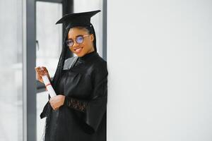 gelukkig Afrikaanse Amerikaans vrouw leerling met diploma Bij diploma uitreiking foto