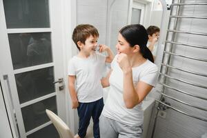 schattig moeder onderwijs kind jongen tanden poetsen foto