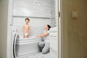 moeder het wassen weinig zoon in badkamer foto