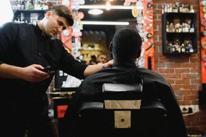 bezoekende kapperszaak. Afrikaanse Amerikaans Mens in een elegant kapper winkel foto