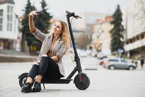 jong vrouw Aan elektro scooter in stad. foto