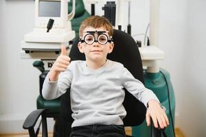 jong jongen ondergaan oog test met bril in medisch kliniek. foto