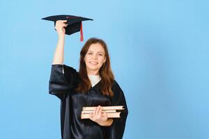 vrouw afstuderen leerling vervelend diploma uitreiking hoed en gewaad, Aan blauw achtergrond foto