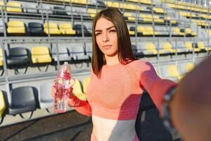 sport en recreatie concept. meisje in sport- slijtage poseren Bij stadion voordat geschiktheid oefening. foto