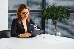 mooie jonge vrouw op de werkplek met behulp van een digitale tablet foto