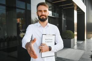 professioneel landgoed verkoper met klembord schrijven documenten buiten in voorkant van verhuurd huis met reclame Oppervlakte foto