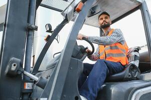 Mens werken Bij magazijn en het rijden heftruck foto