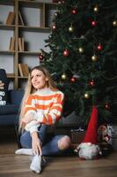 mooi jong vrouw ontspannende Bij huis Aan Kerstmis dag foto