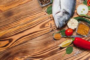 rauw vis Koken en ingrediënten. Dorado, citroen, kruiden en specerijen. top visie met kopiëren ruimte Aan tafel foto