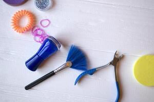 kleurrijk en helder cosmetica. schoonheid zorg hulpmiddelen. schoonheid salon. meisjes paradijs. nagel poetsmiddelen, pailletten, roze haar- bands en kam Aan de wit houten bureau. helder nog steeds leven van schoonheid instrumenten. foto