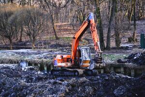 uitgraving in de park. graafmachine werken Aan de meer. foto