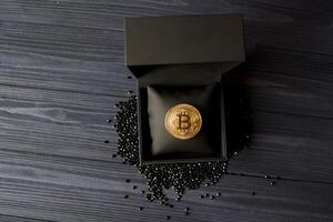 gouden bitcoin in een zwart doos. goud munt van cryptogeld. foto