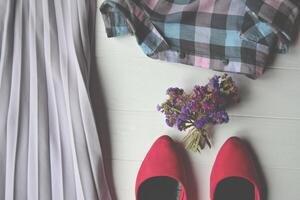 gewoontjes kleding en boeket van bloem Aan de wit houten tafel. foto