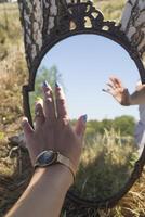 een vrouw hand- in reflectie van de spiegel. foto