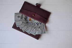 dollar geld bankbiljetten en portemonnee Aan de wit houten achtergrond. Amerikaans munteenheid. geld achtergrond. Verenigde staten dollar foto