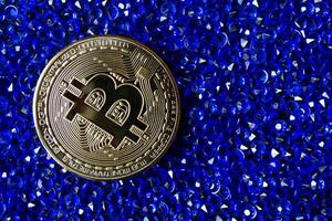 gouden bitcoin Aan de blauw juwelen. foto