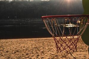 basketbal Aan de zonsondergang strand. basketbal ring Aan de strand. foto