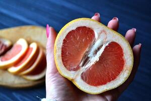 voor de helft van grapefruit in hand. foto