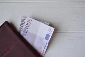 euro geld bankbiljetten en portemonnee Aan de wit houten bureau. bedrijf geld achtergrond. foto