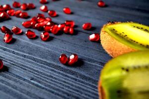 granaat en kiwi fruit Aan de tafel. gezond voedsel. nuttig vruchten. foto