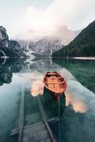 trap die het water in gaat. houten boot op het kristalmeer met majestueuze berg erachter foto