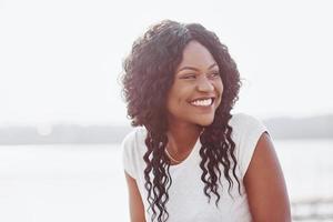 portret van lachende jonge zwarte vrouw met zonlicht flare foto