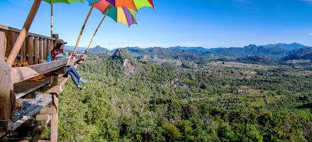 het meisje zit noedels te eten in het landelijke dorp, hangende benenstijl voor gezichtspunt op de berg, de lokale attracties van de provincie Mae Hong Son, Thailand. foto