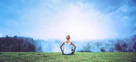 Aziatische vrouwen ontspannen in de vakantie. speel als yoga, natuurlijke grotten, bossen, bergen en mist. foto