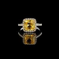 mooi wit goud ring met geel saffier en diamanten Aan een zwart achtergrond foto