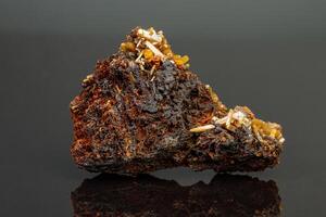 macro mineraal wulfeniet steen Aan een zwart achtergrond foto