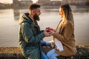 vrouw geven presenteert naar haar Mens terwijl ze genieten uitgeven tijd samen buitenshuis. foto