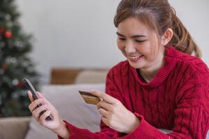 vrouw Holding credit kaart en gebruik makend van smartphone Bij huis, online winkelen, online bankieren, betaling, uitgeven geld, e-commerce Bij op te slaan, credit kaart concept foto