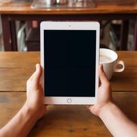 ai gegenereerd handen Holding tablet met blanco scherm Aan houten tafel achtergrond foto