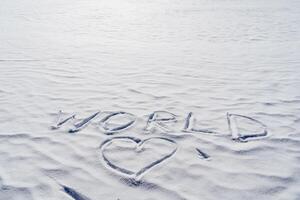 de hart is geschilderd in de sneeuw, de opschrift vrede was geschreven Aan een wit achtergrond van bevroren ijs. de concept van wereld verzoening van de liefde van mensheid. foto