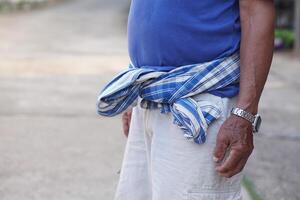 dichtbij omhoog Thais lendendoek gebonden Aan taille van senior Mens. concept, lokaal Mens mode in Thailand. traditioneel levensstijl. lendendoek is een multifunctioneel kleding dat Thais mensen hebben gebruikt sinds oude keer. foto