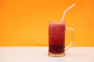 glas van rood fruit smoothie met drinken rietje, oranje achtergrond. concept, gezond drank voor Gezondheid. goed wezen en gewicht verlies menu. eigengemaakt verfrissend drankjes. hoog vezels, ontgiften. foto