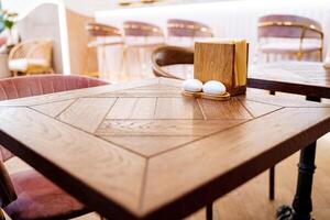 houten tafel in de cafe servet staan wit zout shaker en peper shaker. foto